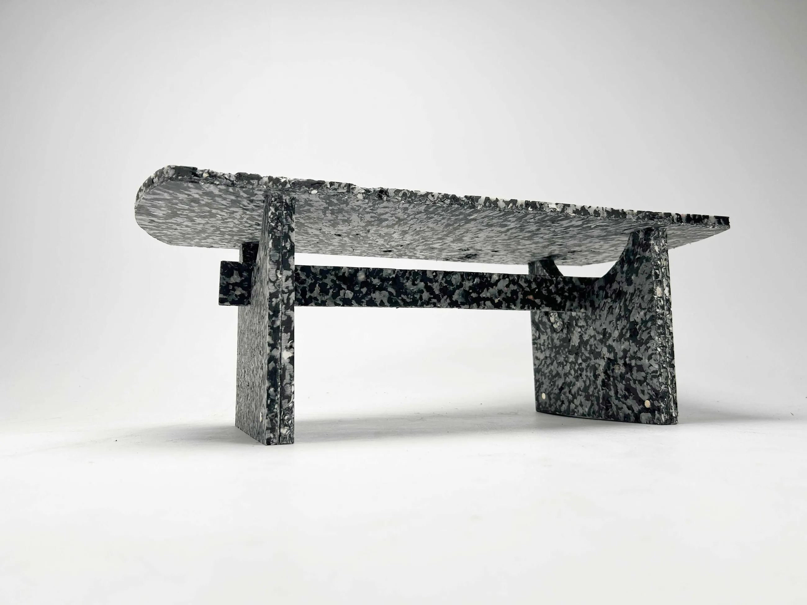 Shio, a modular bench pressed from recycled HDPE and crushed oyster shell, photographed on white seamless.